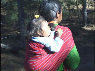 Melina takes her turn carrying her little sister